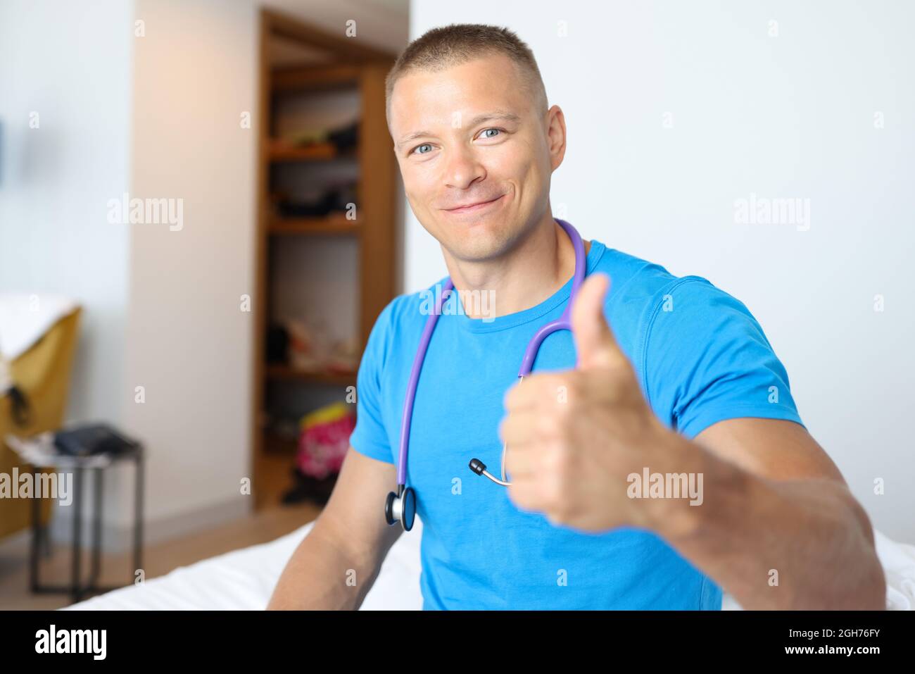 Smiling male doctor making thumbs up gesture Stock Photo