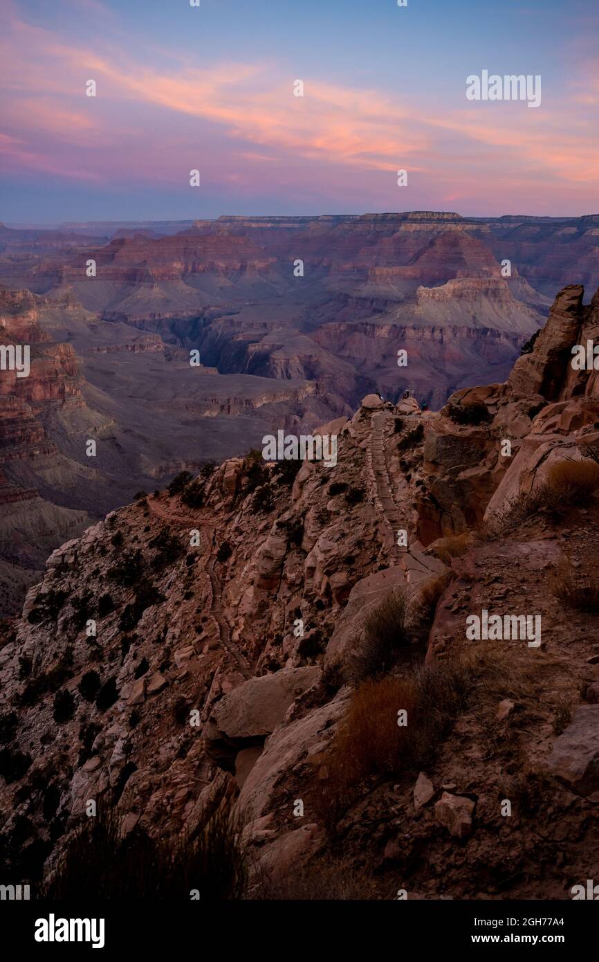 HIkers Look Out From Ooh Ahh Point along the South Kaibab trail at sunrise Stock Photo