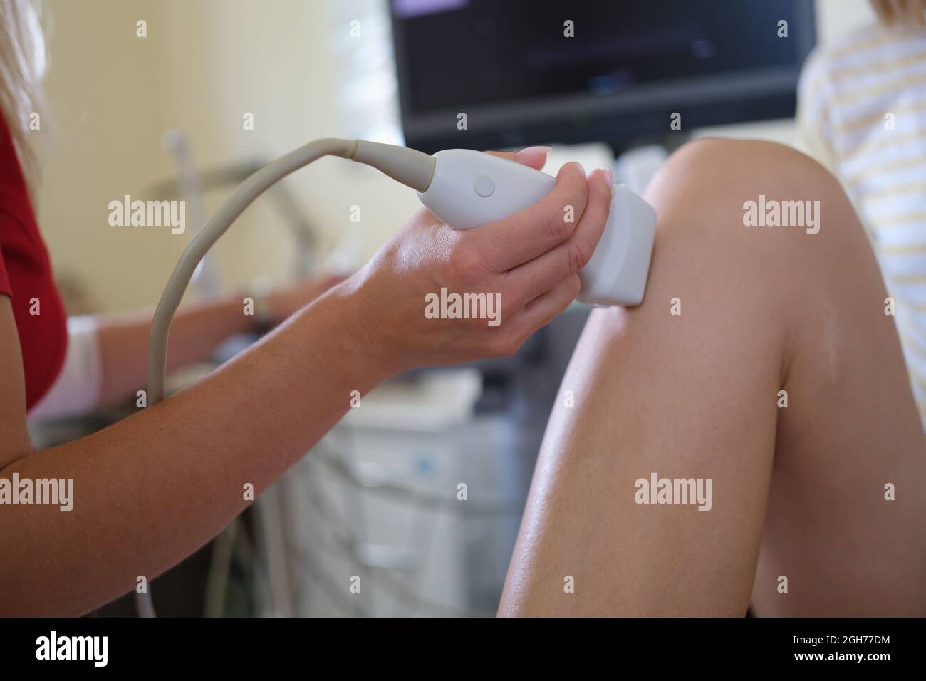 Doctor conducting ultrasound examination of patient knee joint in clinic closeup Stock Photo