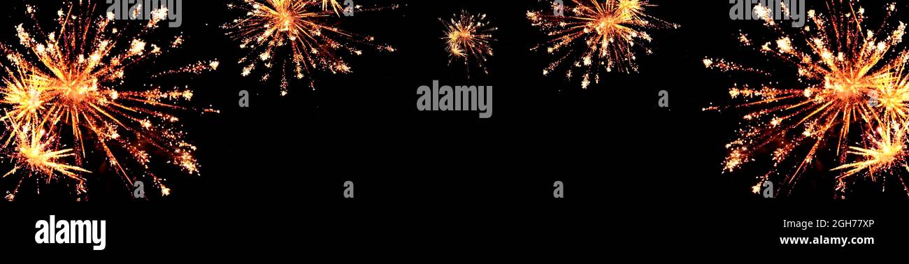 Fireworks banner. New Year and Christmas banner.Sparks salute isolated on black background. Festive banner with flashes of fireworks.Festive fireworks Stock Photo