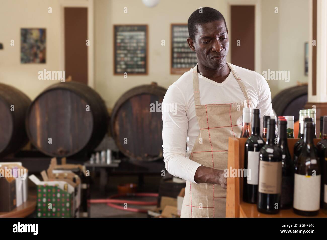 Salesman working in wine house arranging wine bottles Stock Photo Alamy