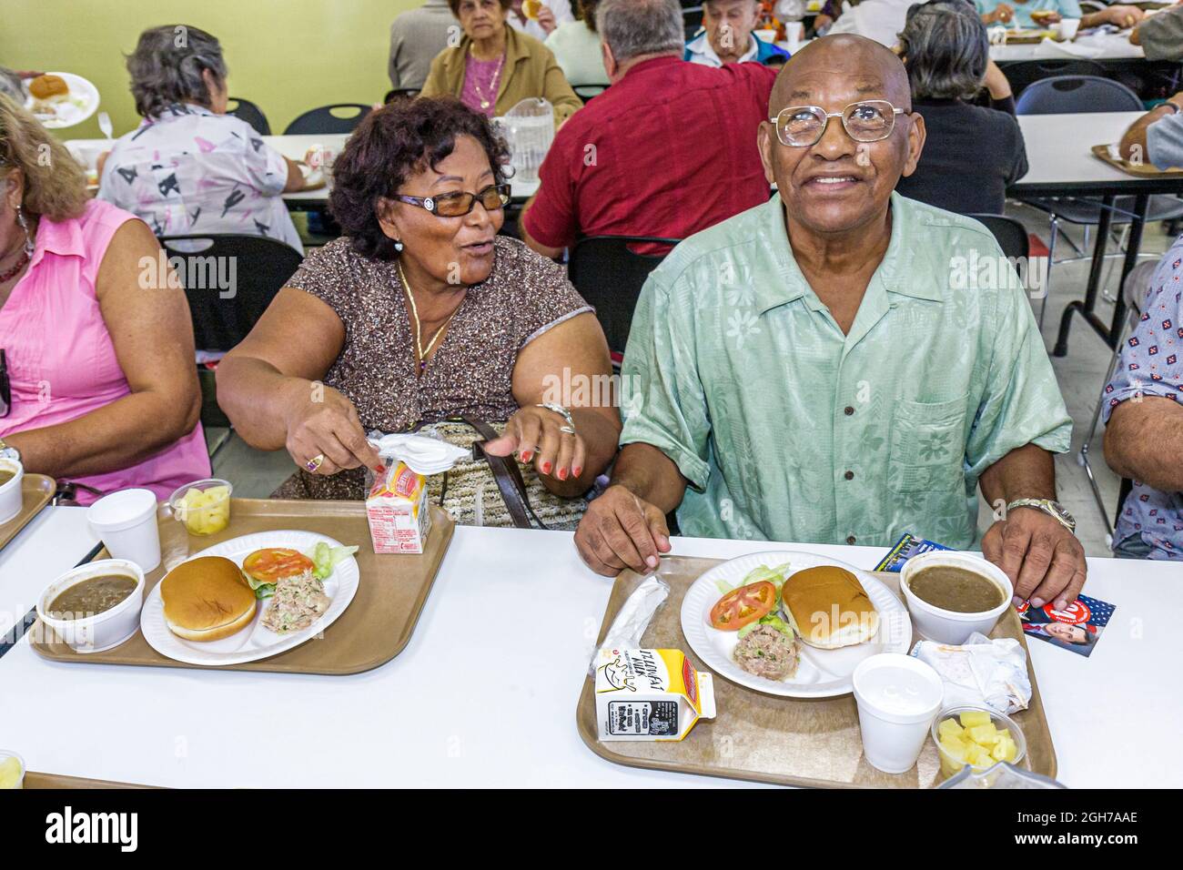 Miami Florida,Allapattah Community Center,low income seniors senior free lunch Black social program,man male woman female couple food eating table Stock Photo