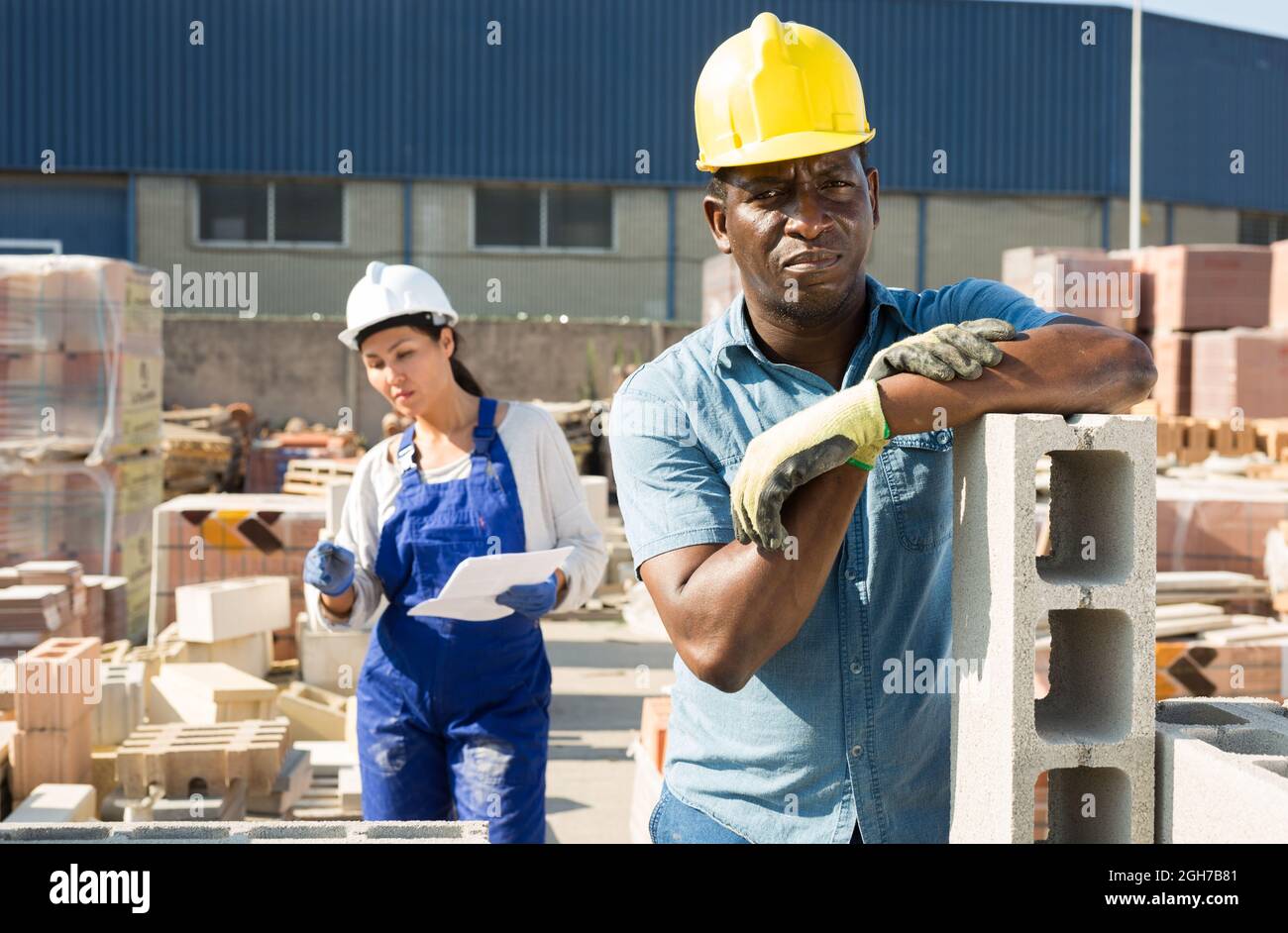 Worker stacking bricks in warehouse of building materials clpseup Stock