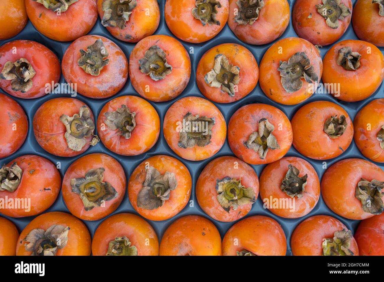 Delicious ripe persimmon fruits close-up on the market stall Stock Photo