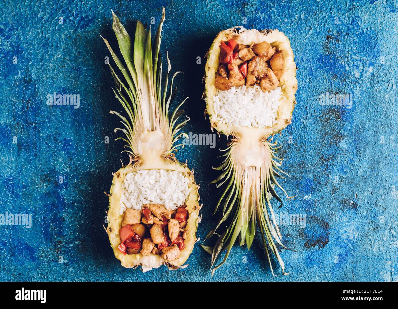 Fried chicken with rice in half of pineapple on the rustic background ...