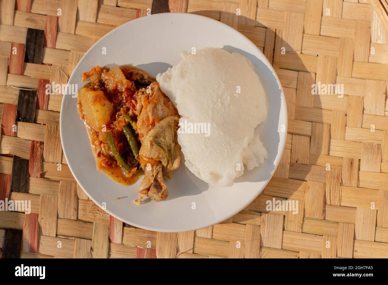 A plate containing traditional African corn meal pap staple food and chicken stew Stock Photo