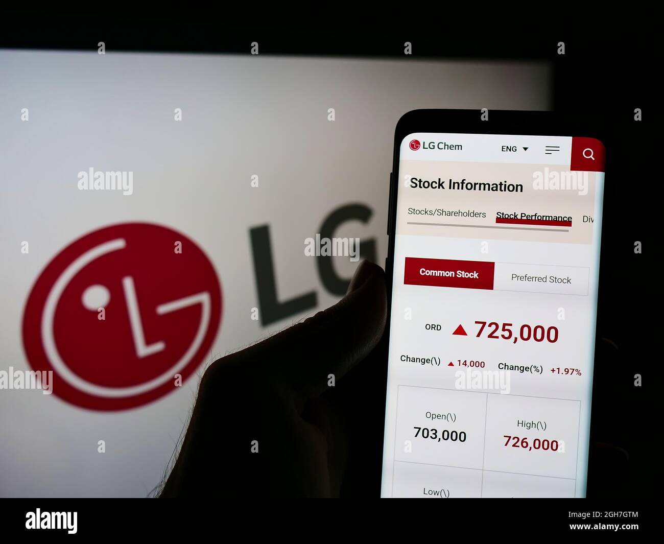 Person holding smartphone with website of South Korean chemical company