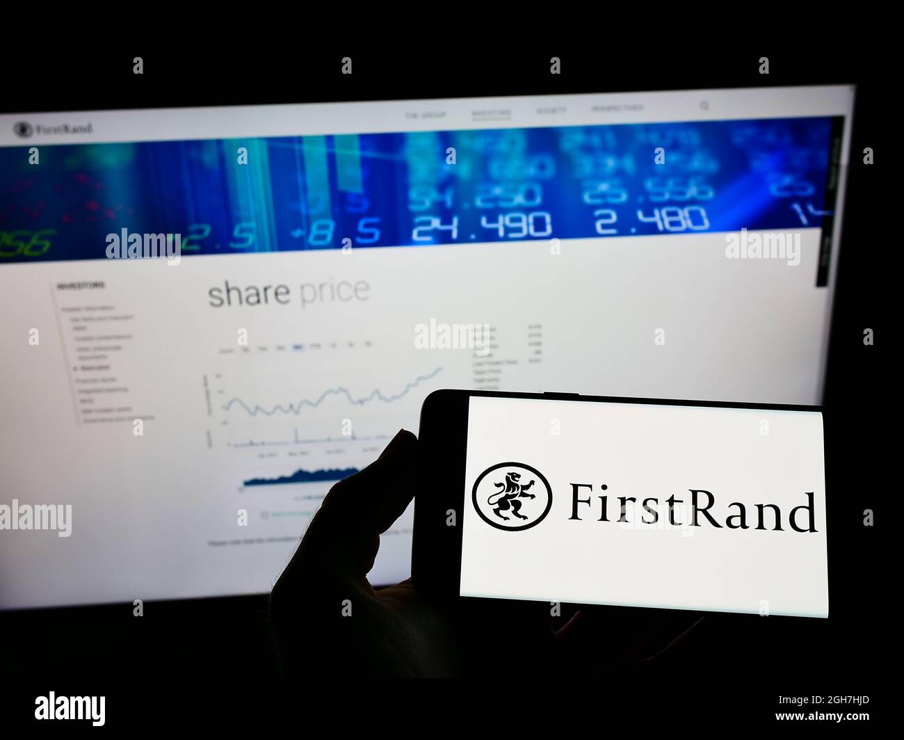 Person Holding Mobile Phone With Logo Of South African Bank Firstrand Limited On Screen In Front Of Business Web Page Focus On Phone Display Stock Photo Alamy