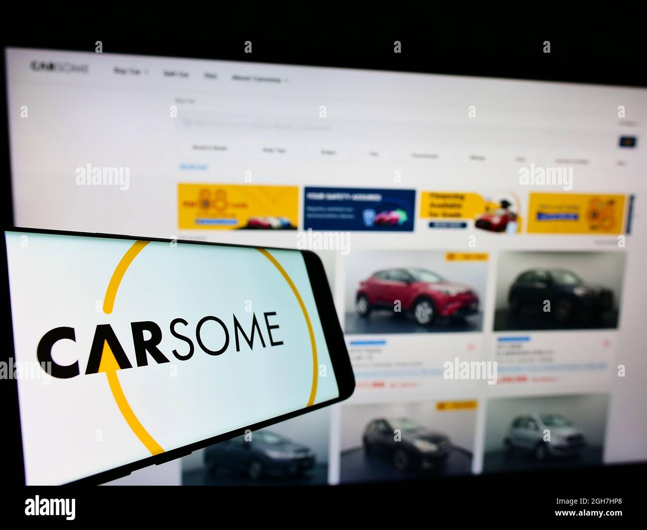Cellphone with logo of Malaysian used car platform company Carsome Group on screen in front of business website. Focus on center of phone display. Stock Photo