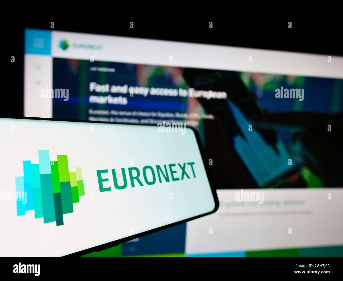 Cellphone with logo of financial services company Euronext N.V. on screen in front of business website. Focus on center-left of phone display. Stock Photo