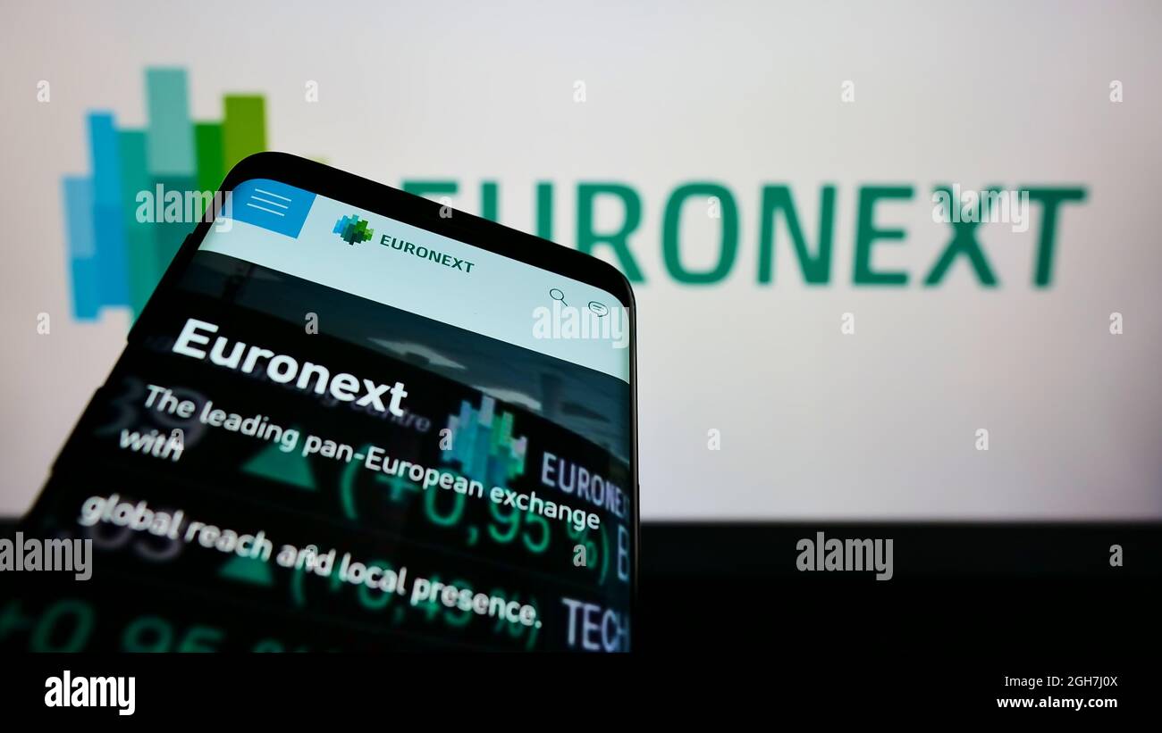 Smartphone with website of financial services company Euronext N.V. on screen in front of business logo. Focus on top-left of phone display. Stock Photo