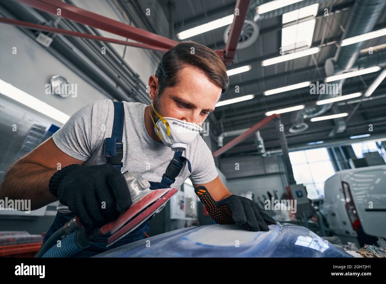 Professional car mechanic looking at grinded surface Stock Photo