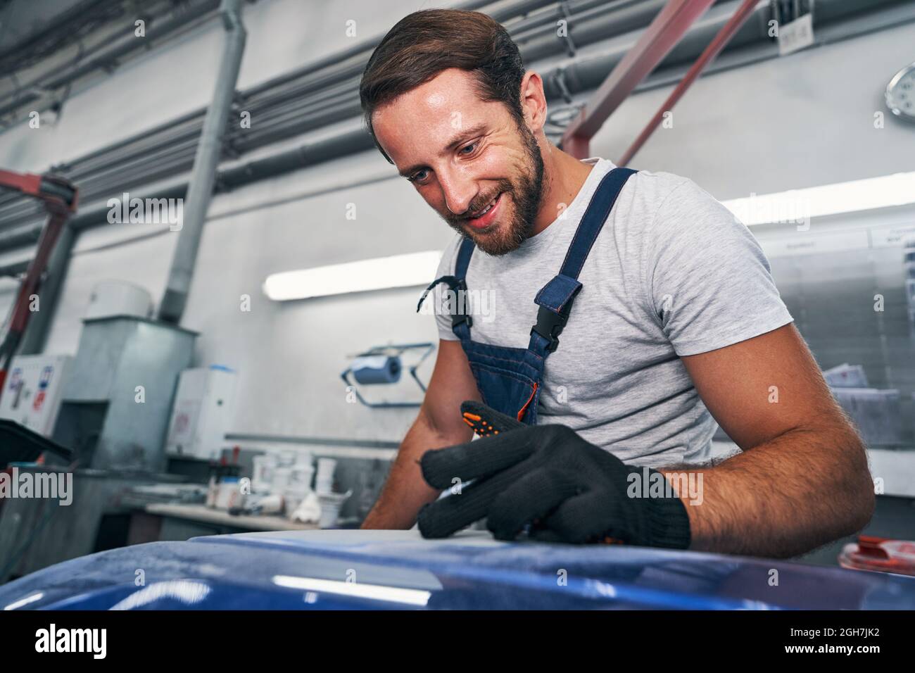Automotive repairman checking quality of grinded surface Stock Photo