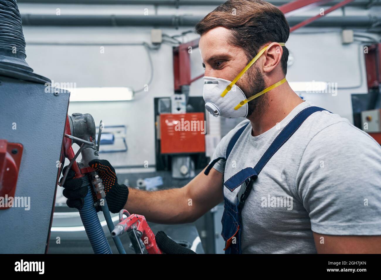 Repairman taking sander tool from air compressor unit Stock Photo