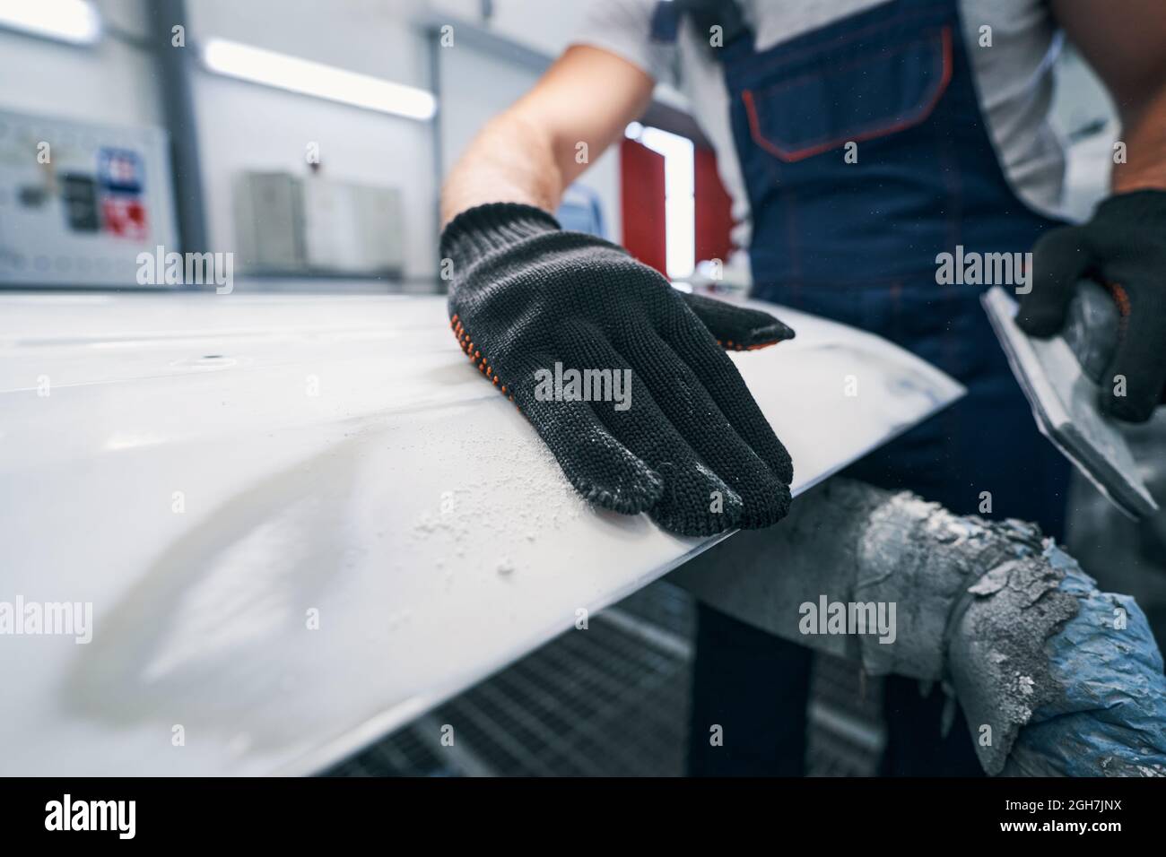 Repairman swiping his palm over a grinded metal surface Stock Photo