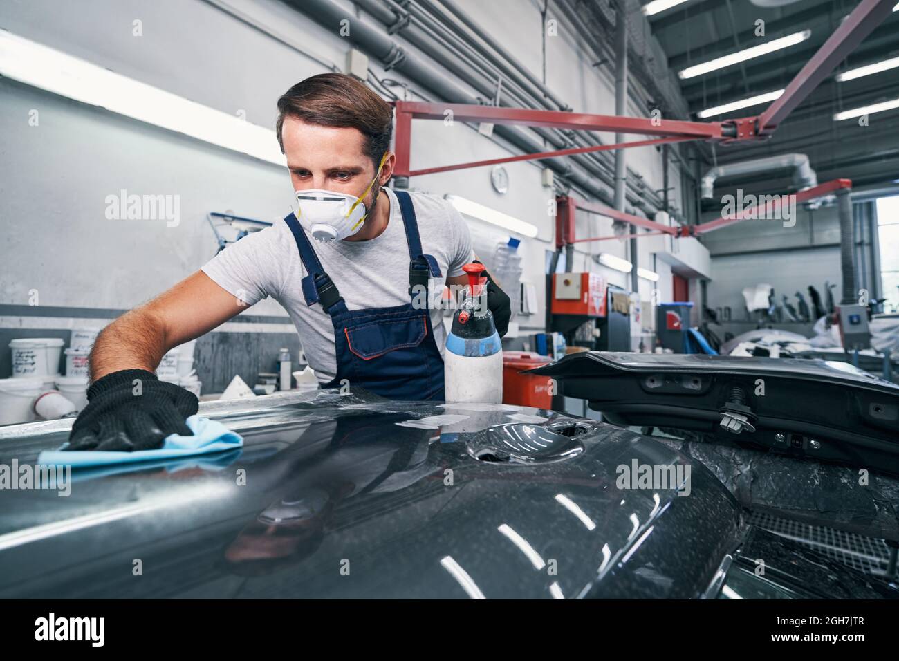 Car cleaning performed by auto mechanic in workshop Stock Photo