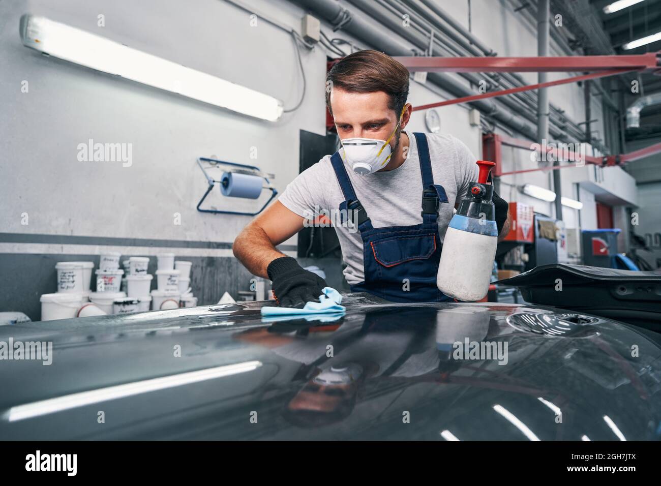 Car repairman wiping car surface with cloth Stock Photo