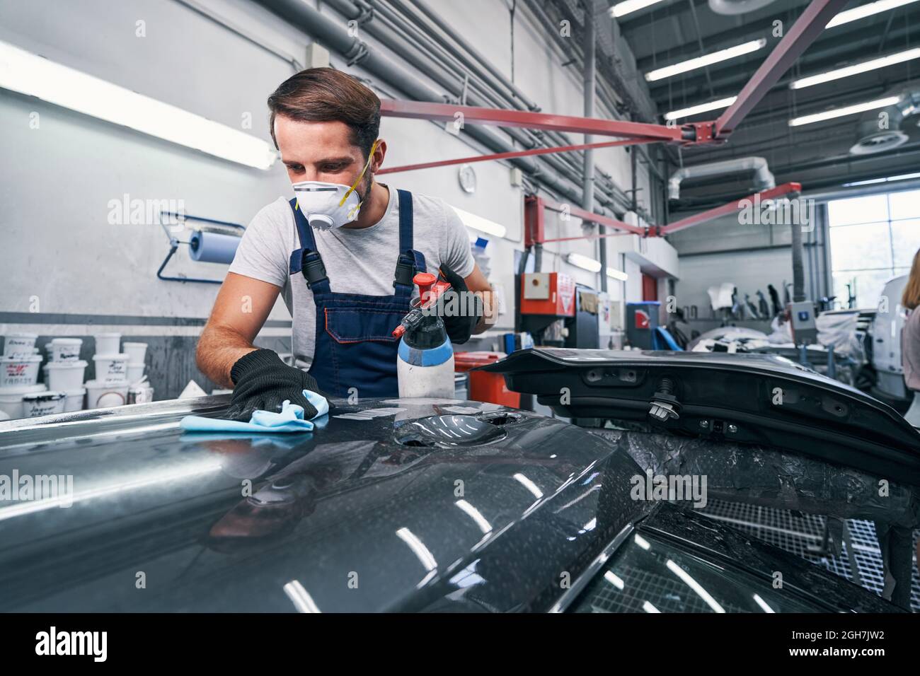 Mechanic washing car part and drying it with cloth Stock Photo