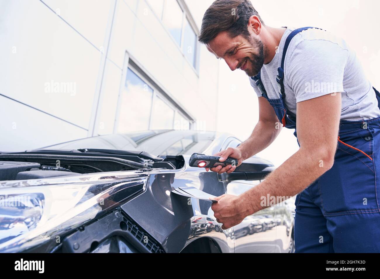 Caucasian repair service mechanic choosing colour for painting car Stock Photo