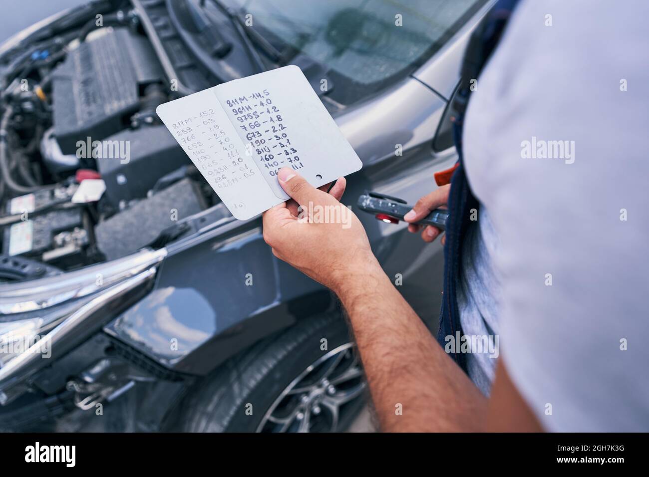 Man looking at colour codes for paint on cards flipside Stock Photo