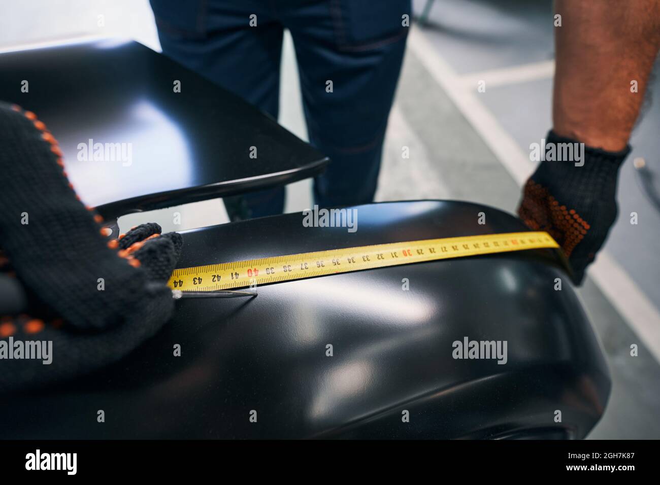 Person using measuring tape while noting a length with tool Stock Photo