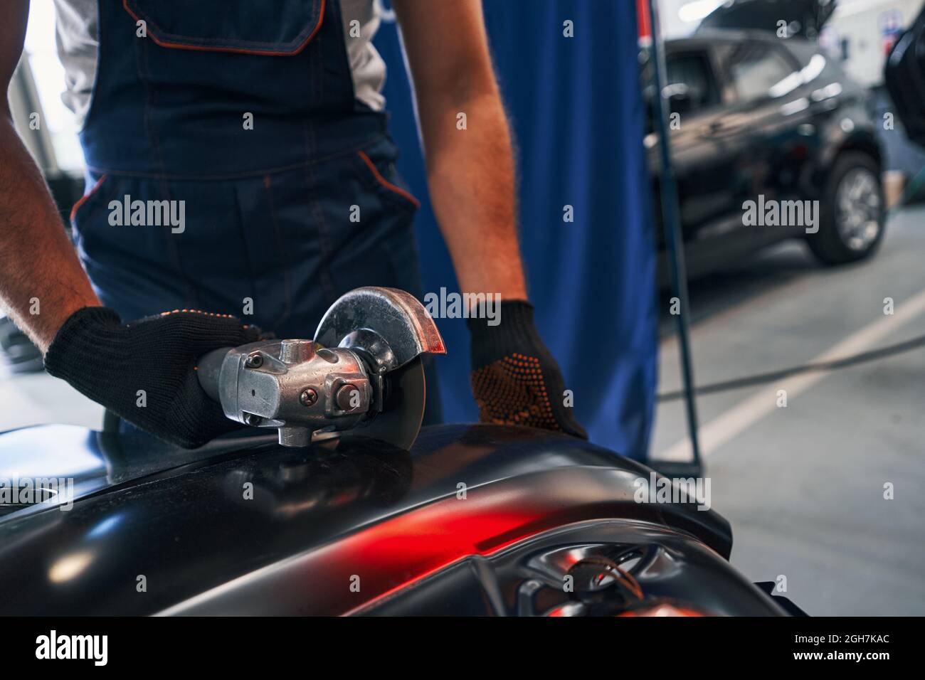 Angle grinder cutting through a piece of metal in workshop Stock Photo