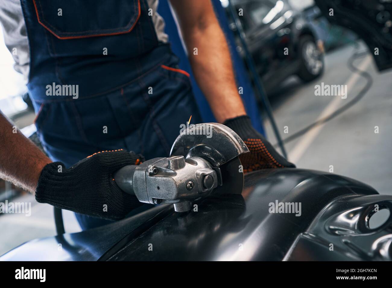 Repairman working with side grinder on car detail Stock Photo