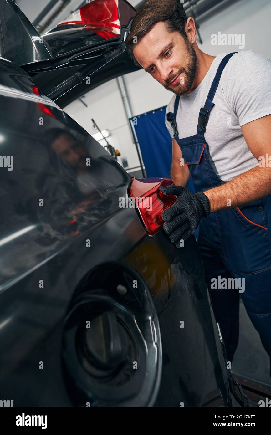 Man adjusting taillight on an automobile Stock Photo
