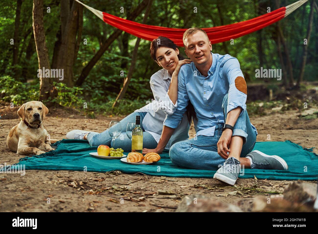 Smiling young couple during romantic picnic with dog Stock Photo - Alamy