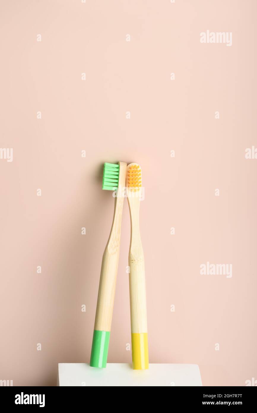 Two yellow and green eco friendly natural bamboo toothbrushes on podium ...