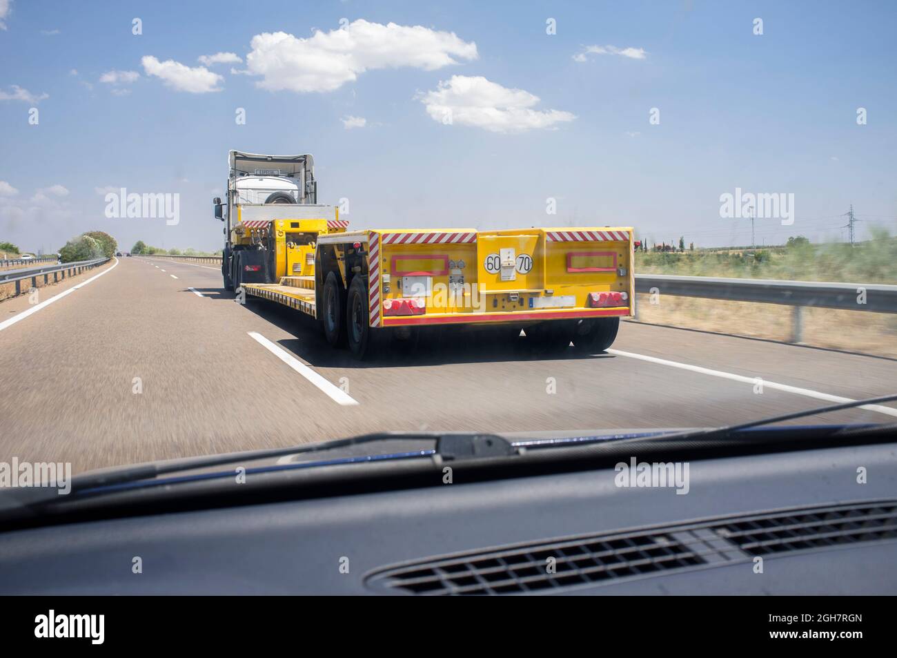 Driving behind empty oversize load truck. View from the inside of the car Stock Photo Alamy