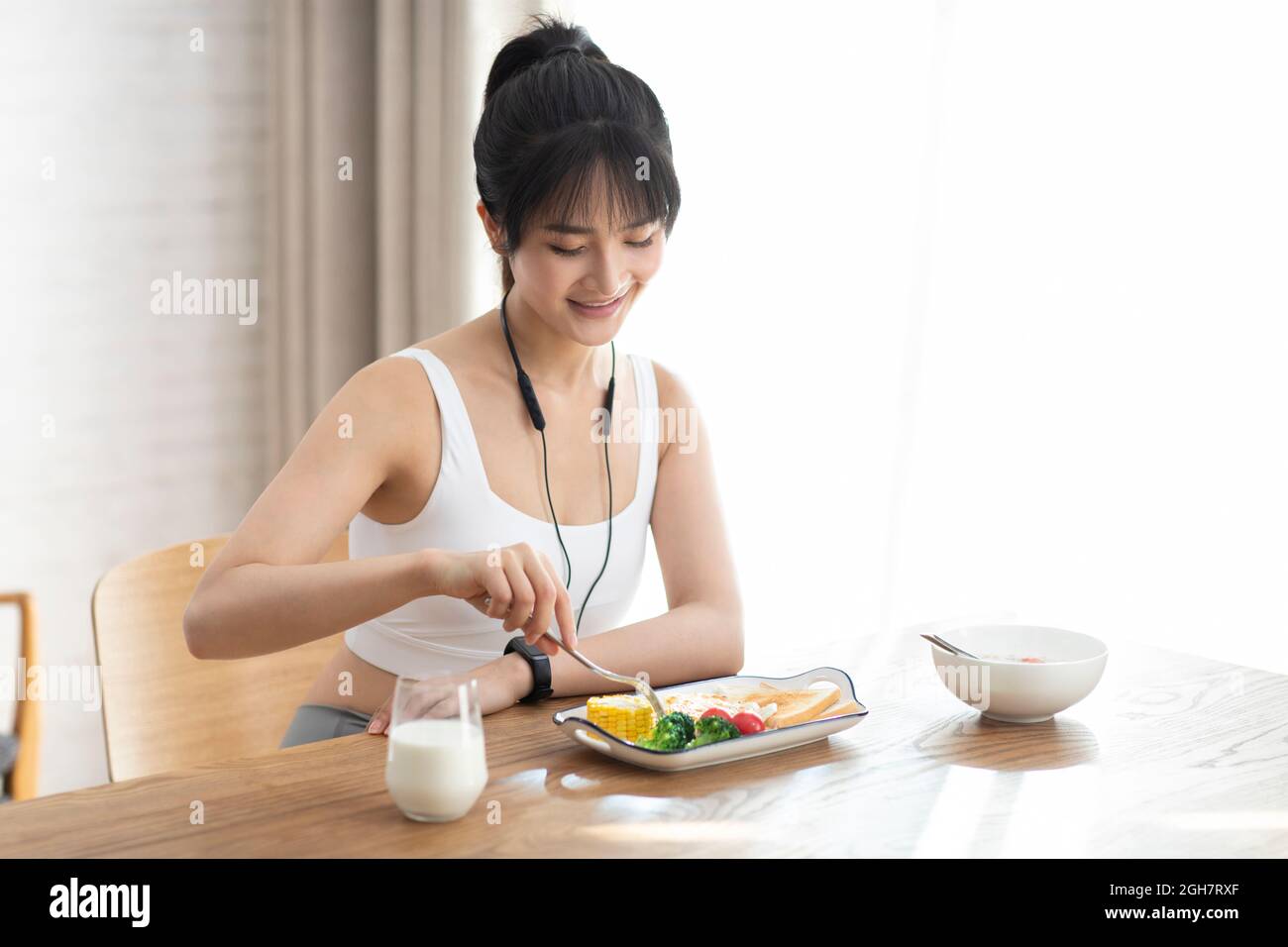 Young woman having breakfast at home Stock Photo