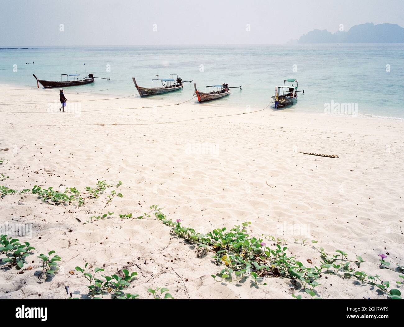 Long-tail boats at Long Beach, Phi Phi island, looking towards Koh Phi Phi Lee ,Krabi, Thailand. Stock Photo