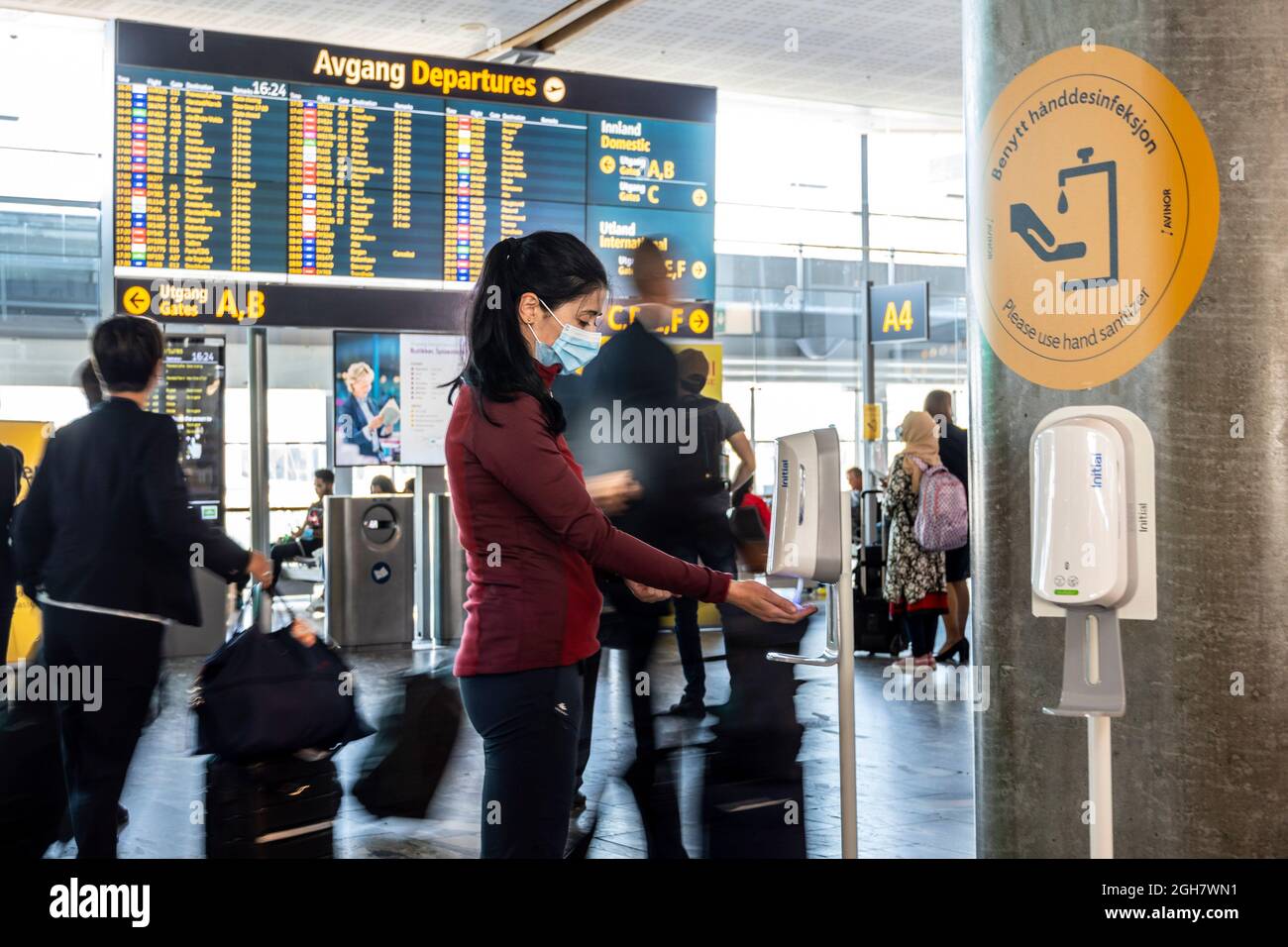 Young woman wearing face mask uses hand sanitizer gel to protect from  Covid-19 at the Oslo Gardermoen Airport in Oslo, Norway, Europe Stock Photo  - Alamy