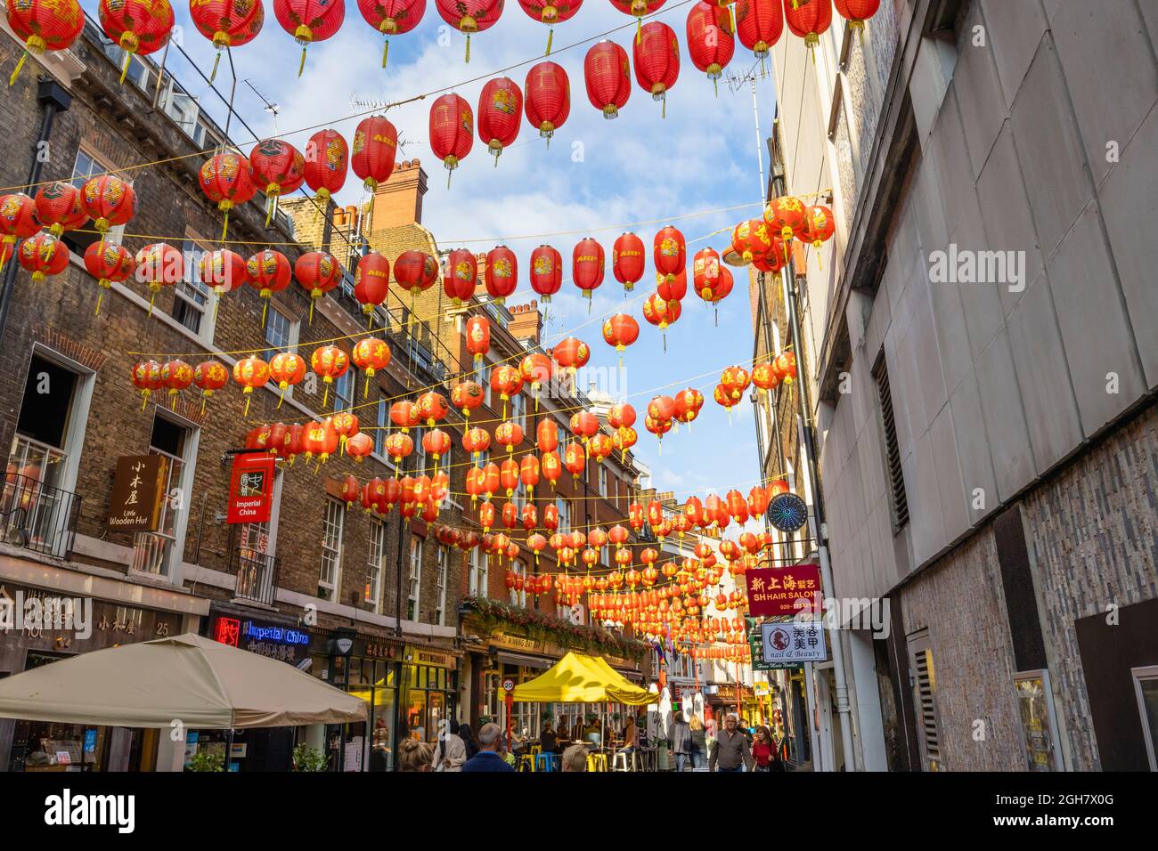 Colourful red and gold Chinese lanterns strung across Lisle Street in Chinatown in the West End of London, City of Westminster W1 district Stock Photo