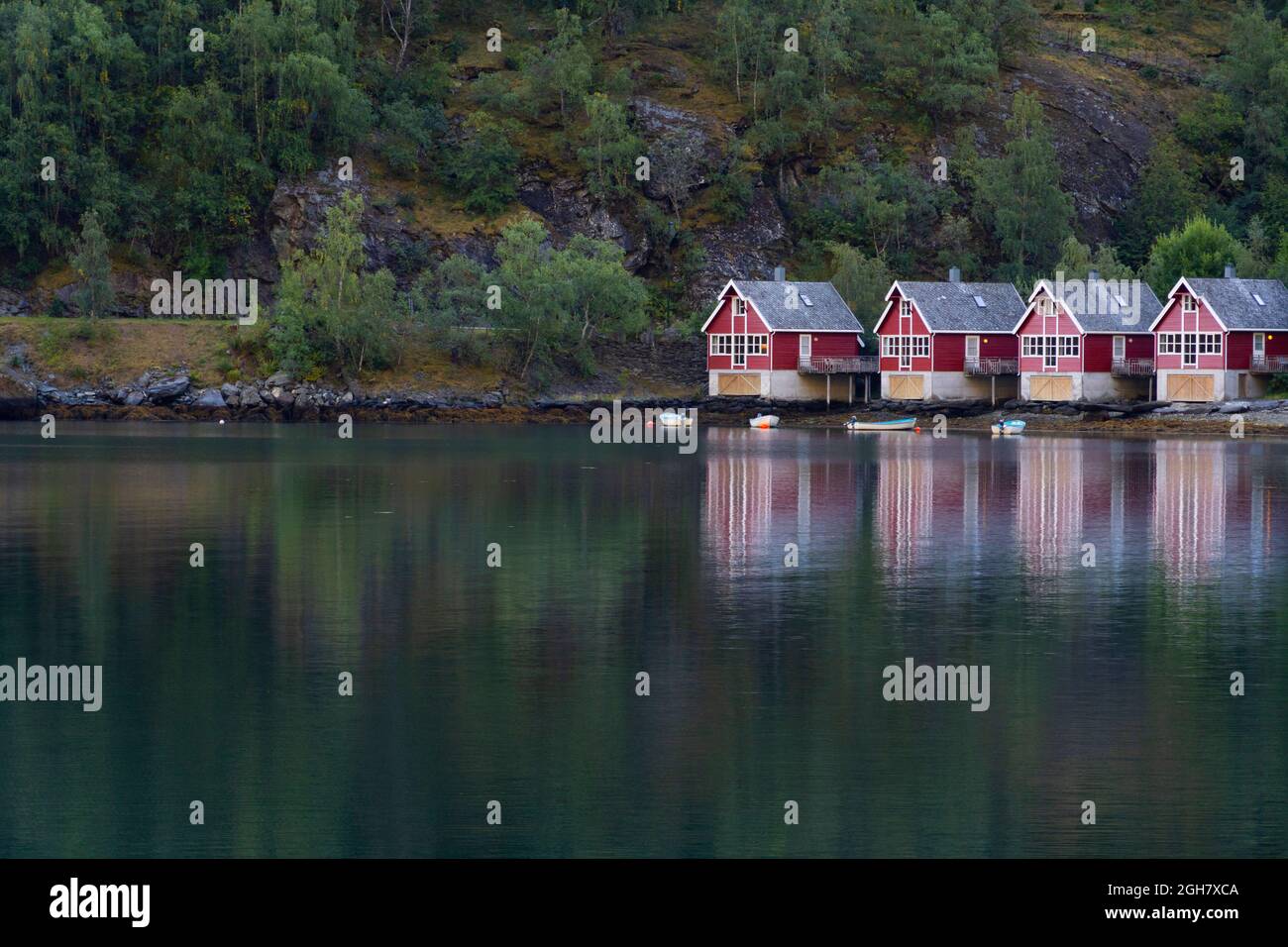 Row of four traditional red wood houses by the fjord water in Flam