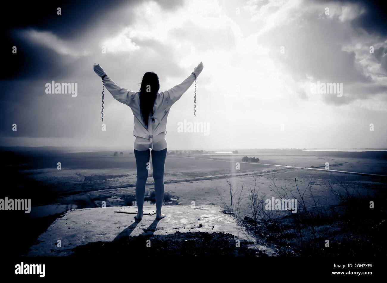 Freedom, a dramatic image of a woman who has escaped still wearing a straightjacket and chains Stock Photo