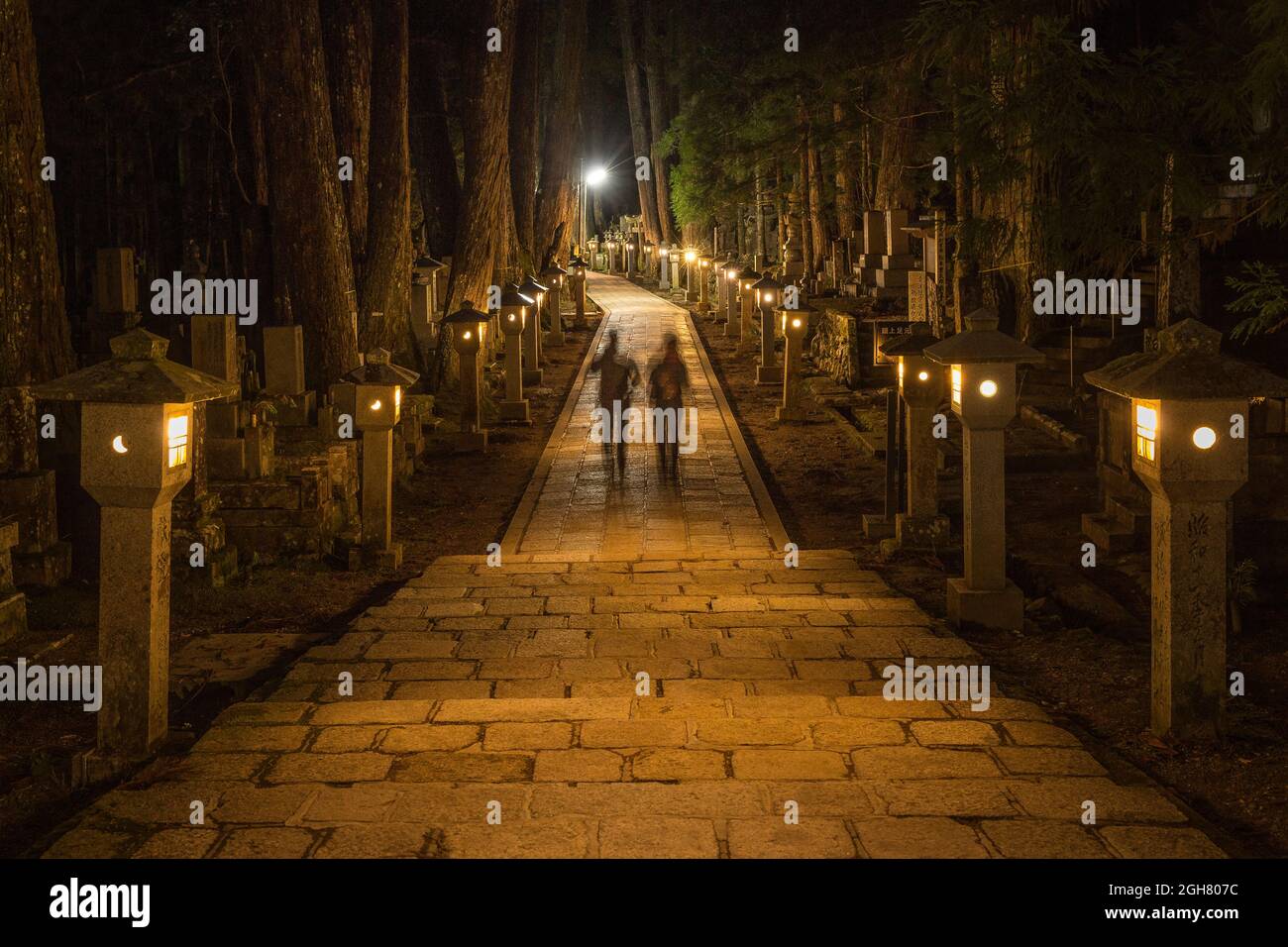 People walking on a path in the nighttime in Okunoin Graveyard, Japan Stock Photo