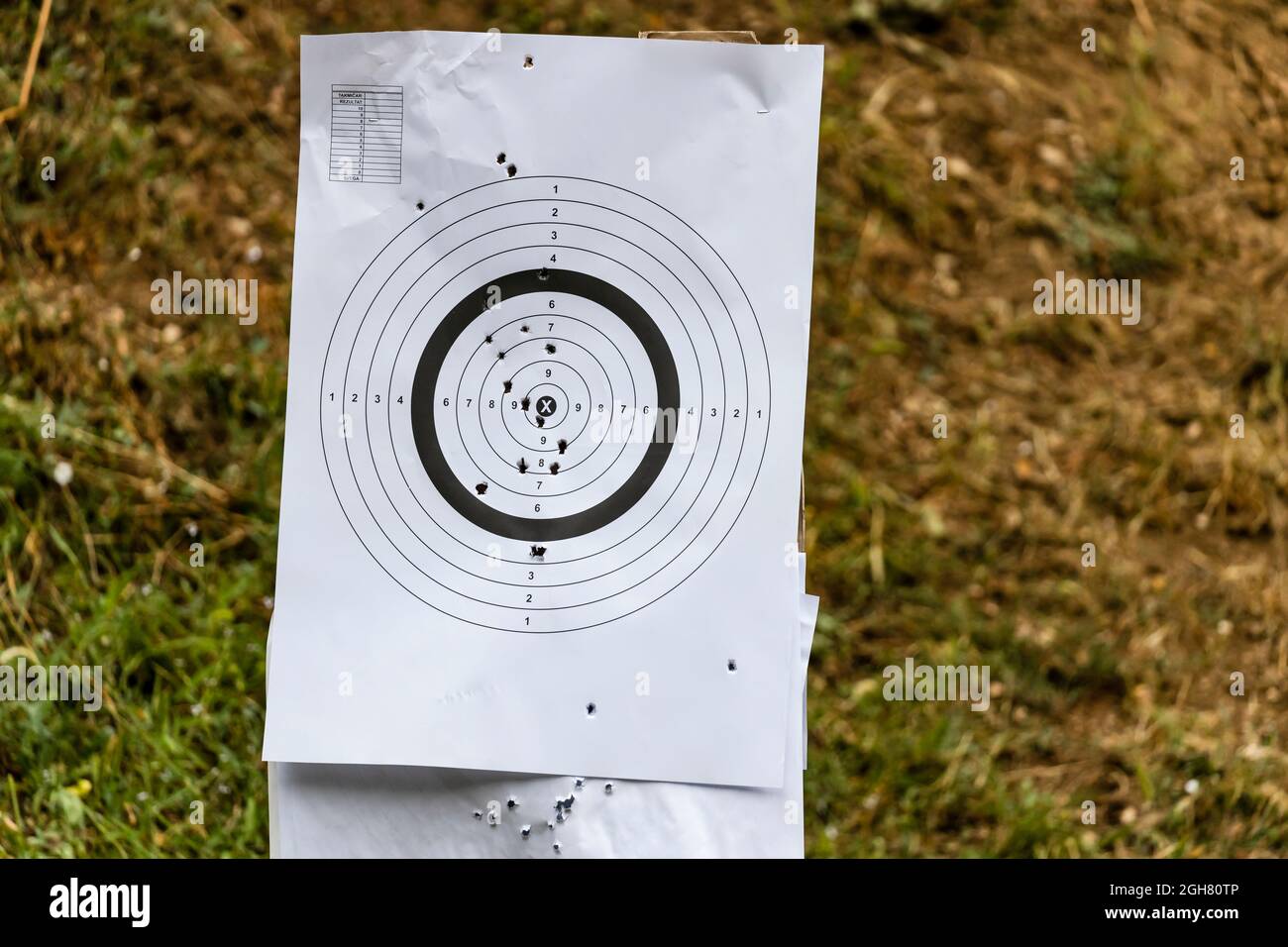 Paper target on a shooting range with bullet holes Stock Photo
