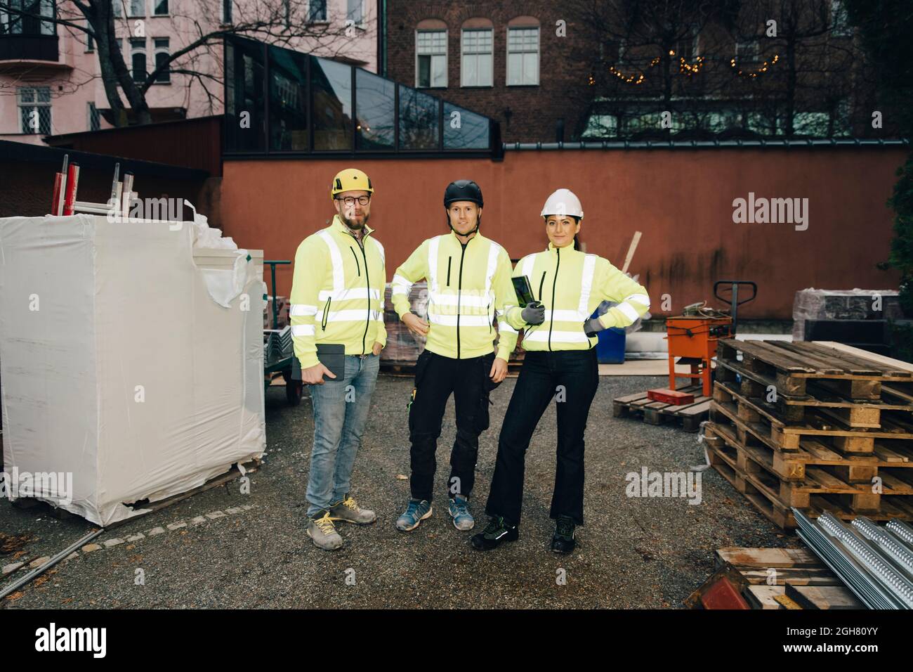 Full length portrait of confident male and female engineers standing at construction site Stock Photo