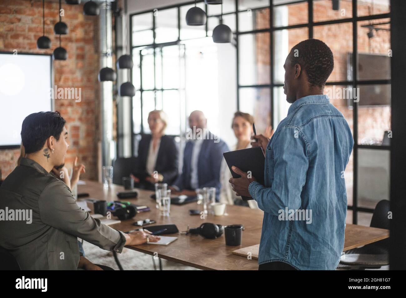 Male hacker presenting ideas with colleagues at creative office Stock Photo