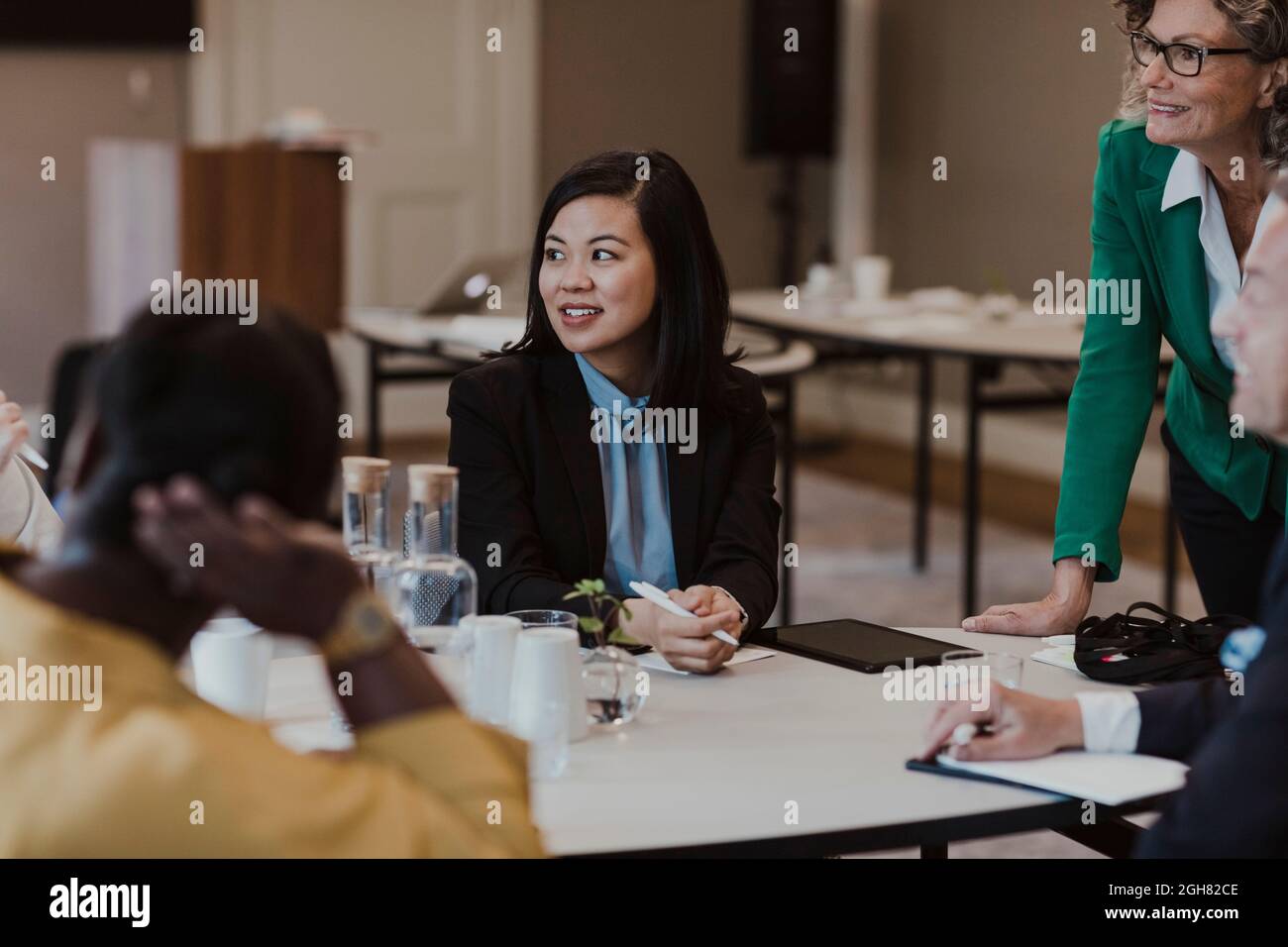 Female colleagues discussing during training session at education class ...