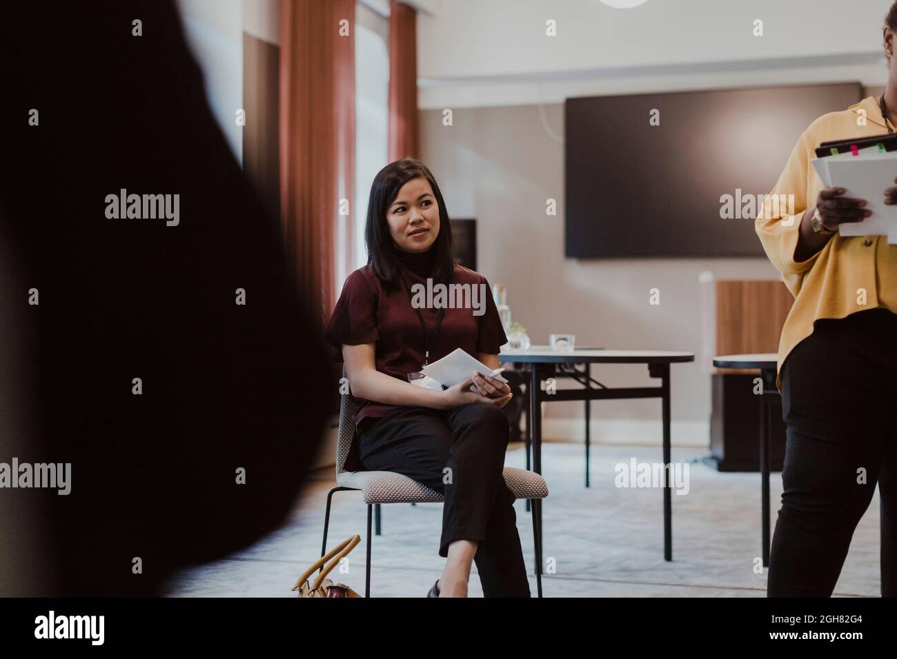 Woman crossed legs standing office hi-res stock photography and images ...