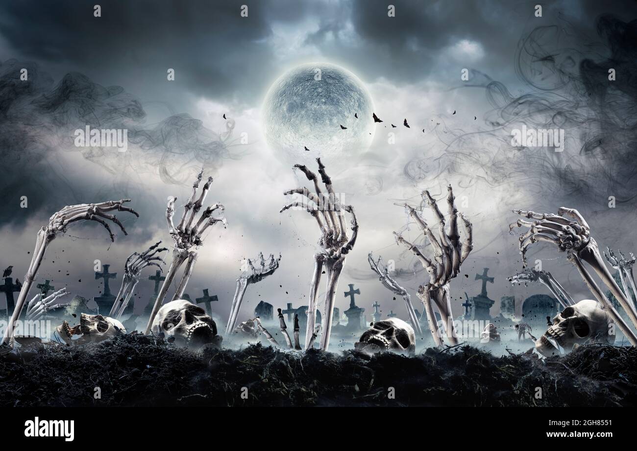 Zombies Rising In Dark - Bones And Skulls Out Of A Cemetery Stock Photo
