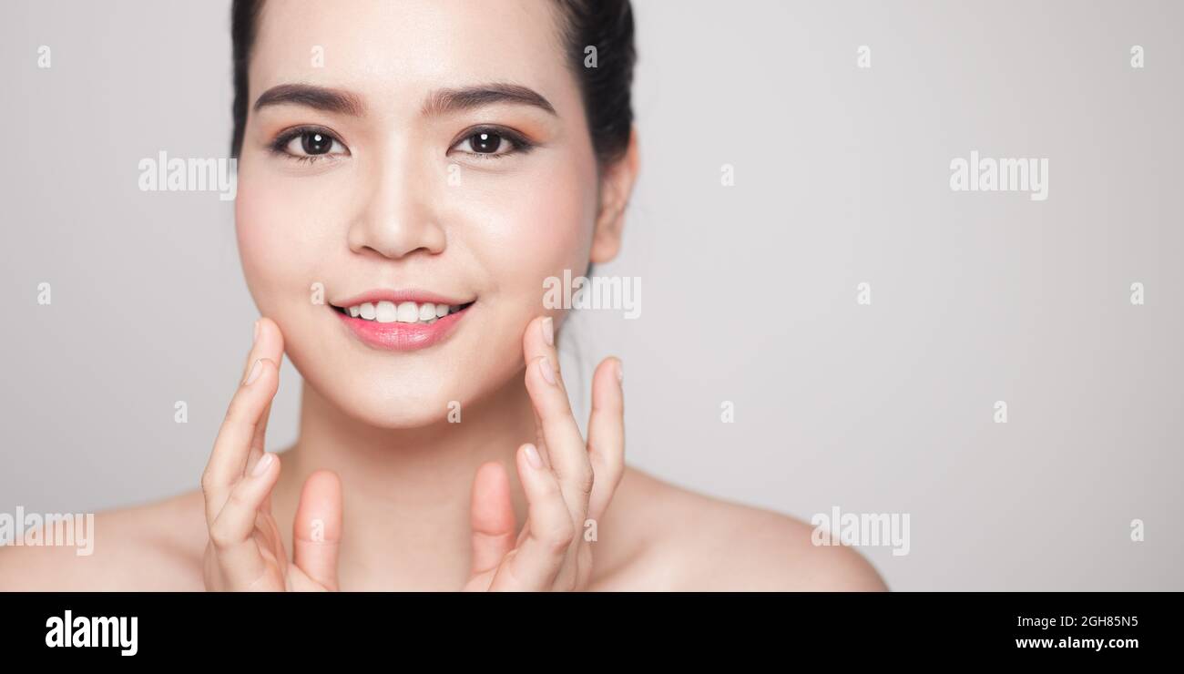 Happy smiling beautiful asian woman touching her face Stock Photo - Alamy