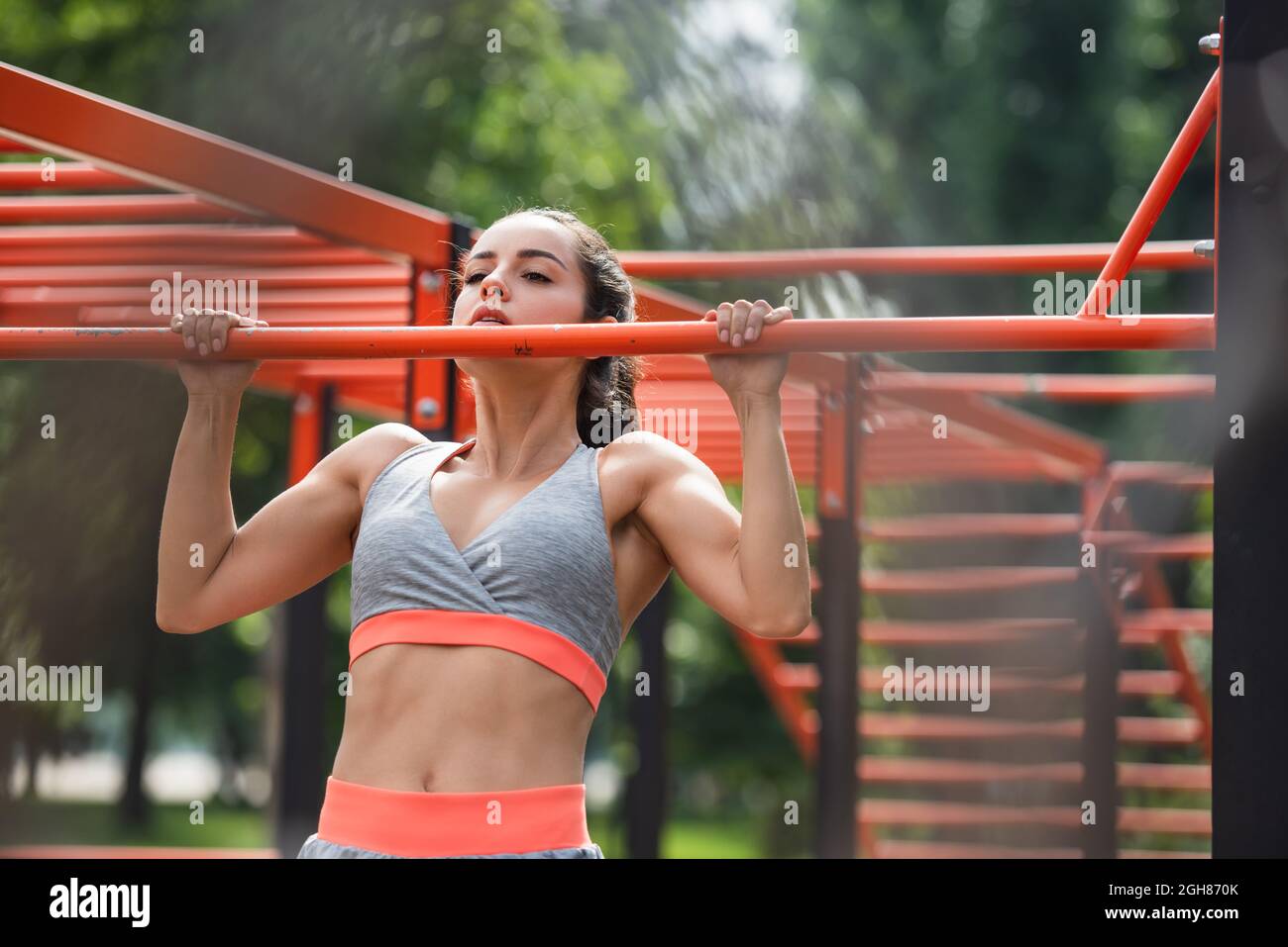 young and strong woman working out on pull up bar in outdoor gym Stock ...
