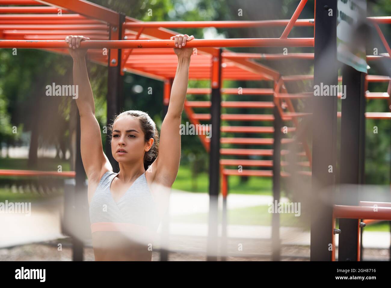 young athletic woman working out on pull up bar in outdoor gym Stock ...