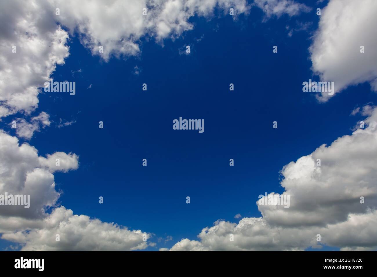 Gap in white clouds showing blue sky on summer day Stock Photo