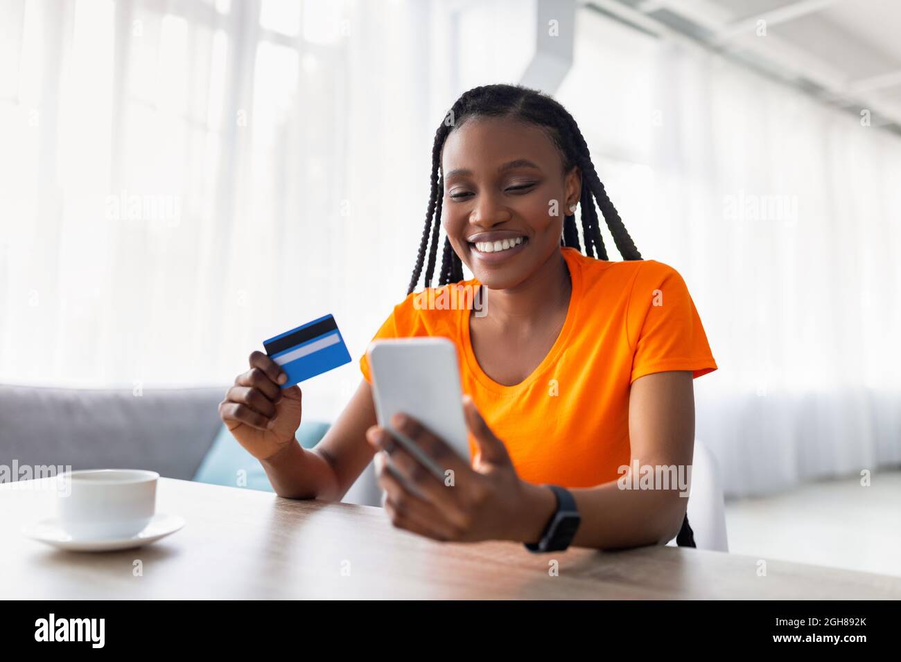 mogelijkheid Abnormaal Ongeëvenaard New online shopping app. Cheerful black woman using mobile phone and credit  card, buying goods in web store Stock Photo - Alamy