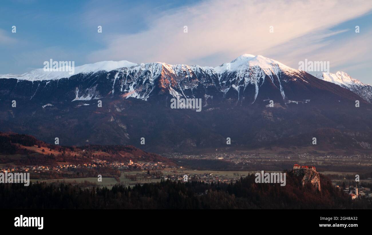 View across to the beautiful Lake Bled's hilltop castle with the Mt Stol  and the Karavanke mountains forming a stunning backdrop. Seen in the  morning Stock Photo - Alamy